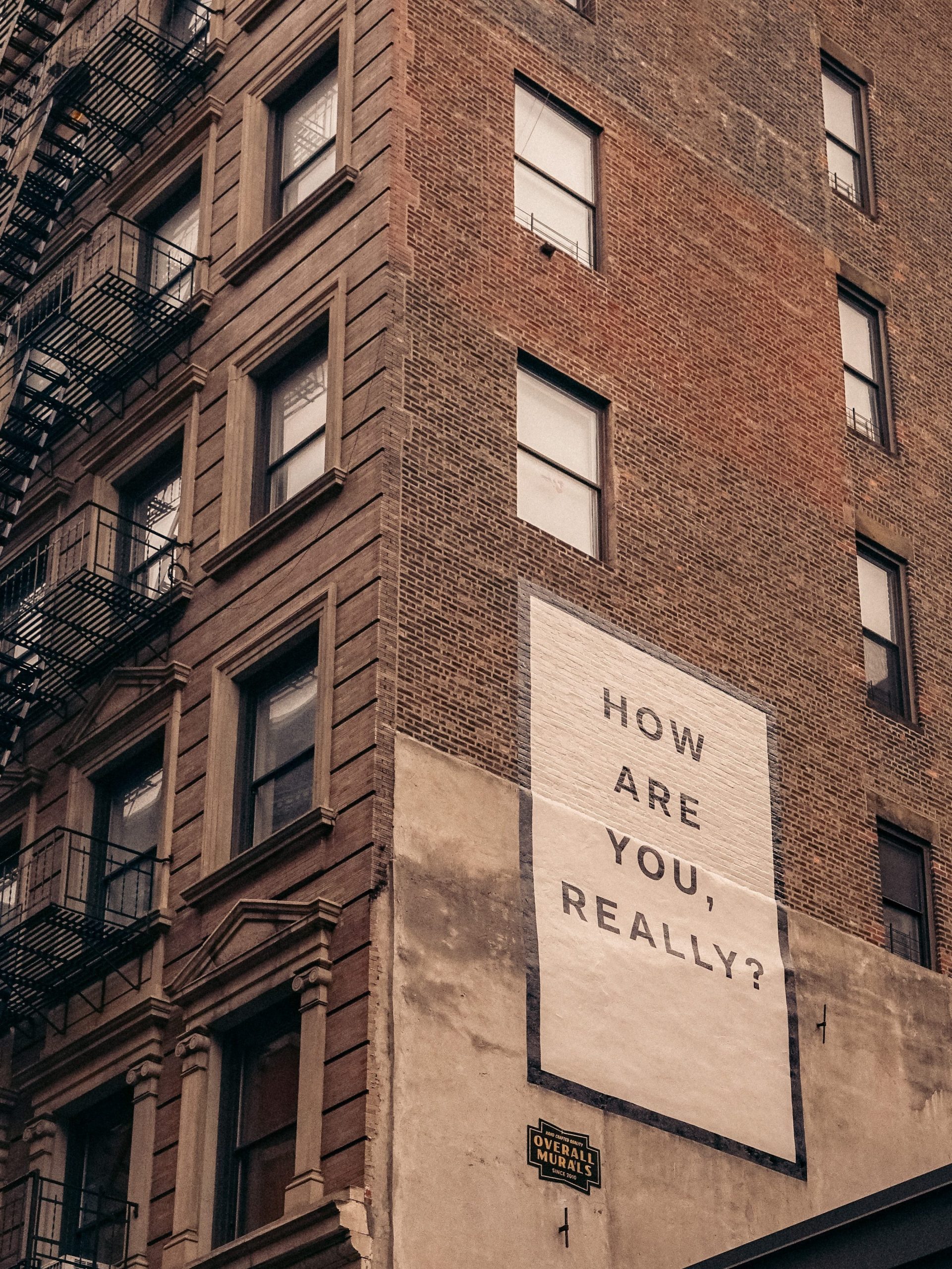 picture of a building with a banner saying 'how are you really?'